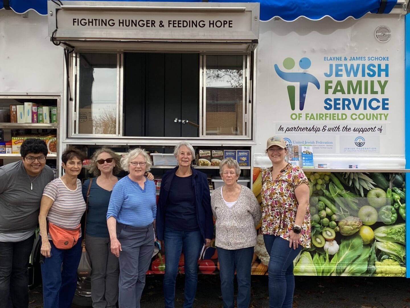 A group of people standing in front of a jewish food truck.